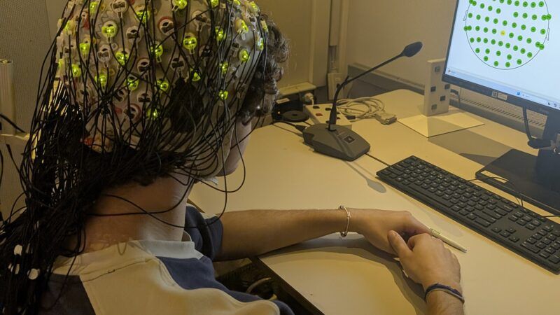 An EEG recording session. Image: Wikimedia Commons (File:EEG Experiment (cropped).jpg), CC0.