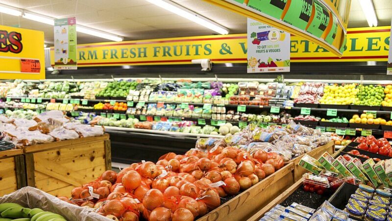 Fresh fruits and vegetables displayed in colourful rows inside a grocery store