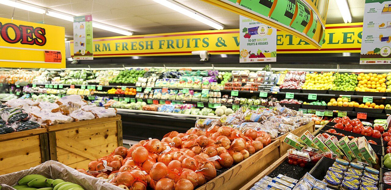 Fresh fruits and vegetables displayed in colourful rows inside a grocery store