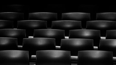 Rows of empty dark cinema seats photographed inside a movie theatre