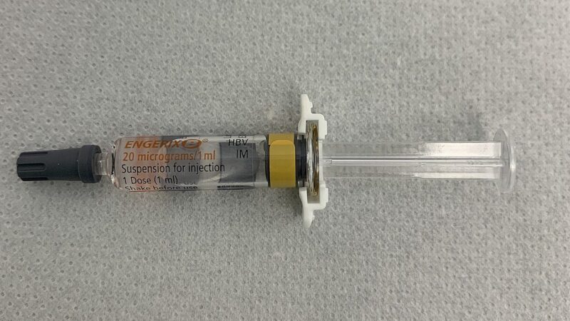 A pre-filled hepatitis B vaccine syringe lying on a clinical surface