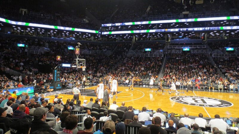 Basketball game in progress before a large crowd inside Brooklyn's Barclays Center arena