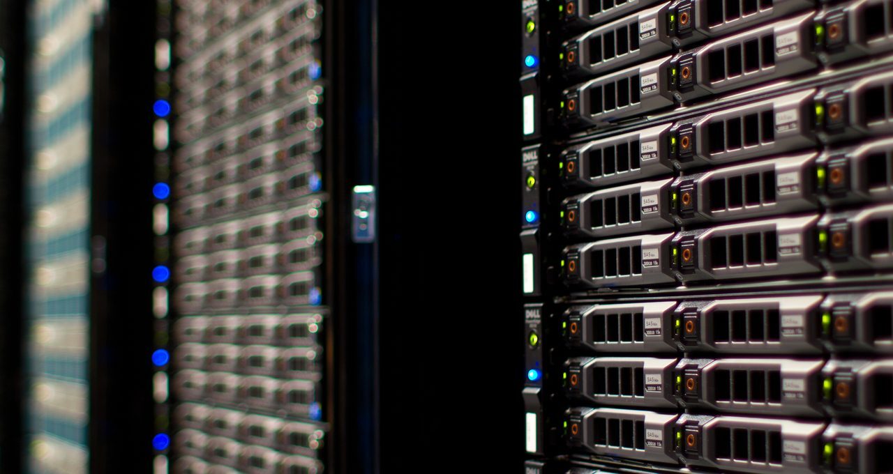 Rows of server racks with blinking lights inside a data centre